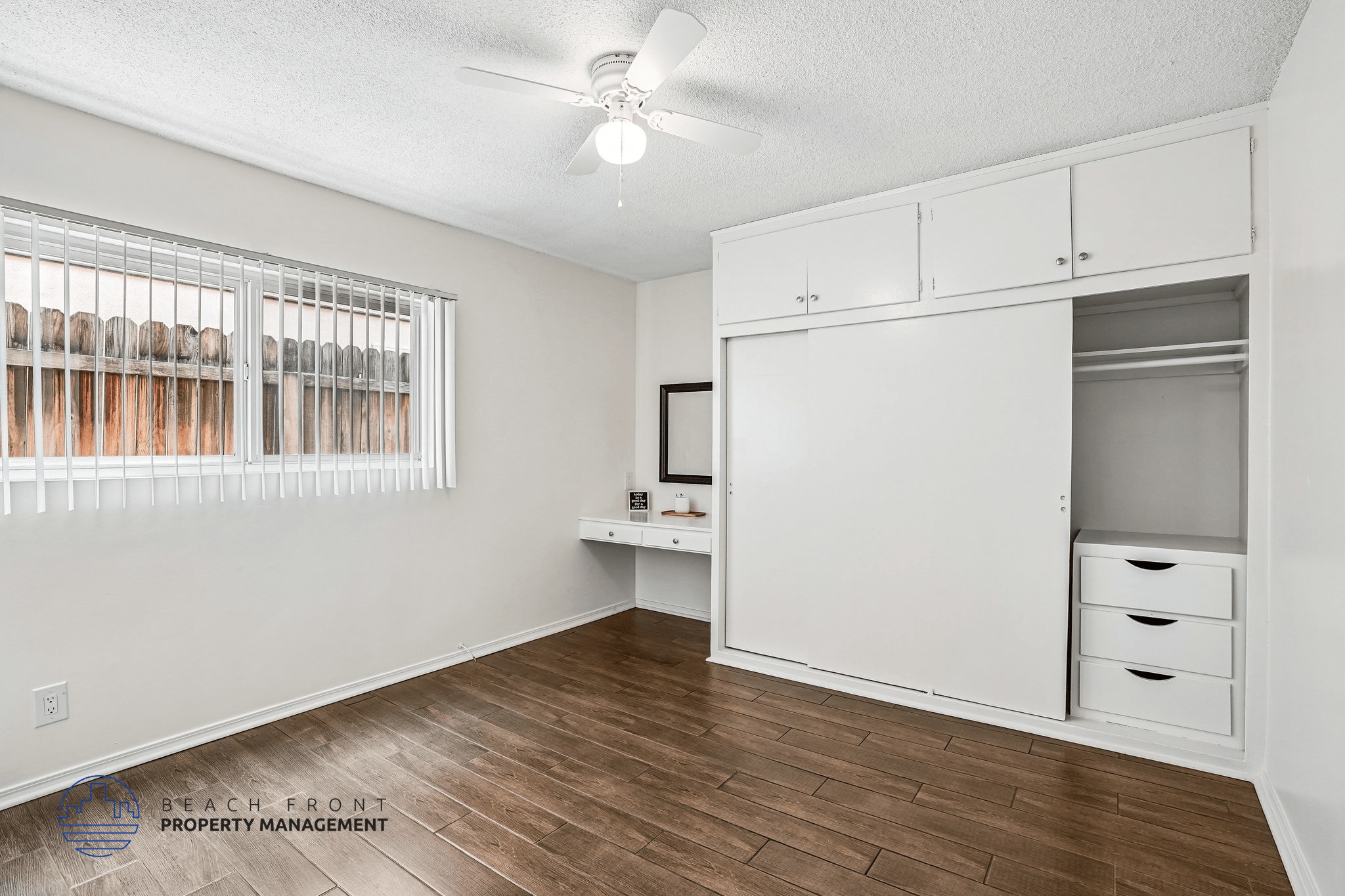 A room with a window, a desk, and a cabinet.